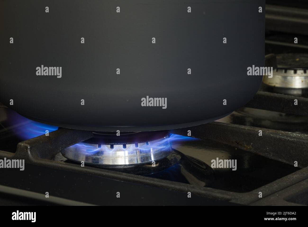 A black pan cooking on natural gas. Concept for gas crisis. Stock Photo