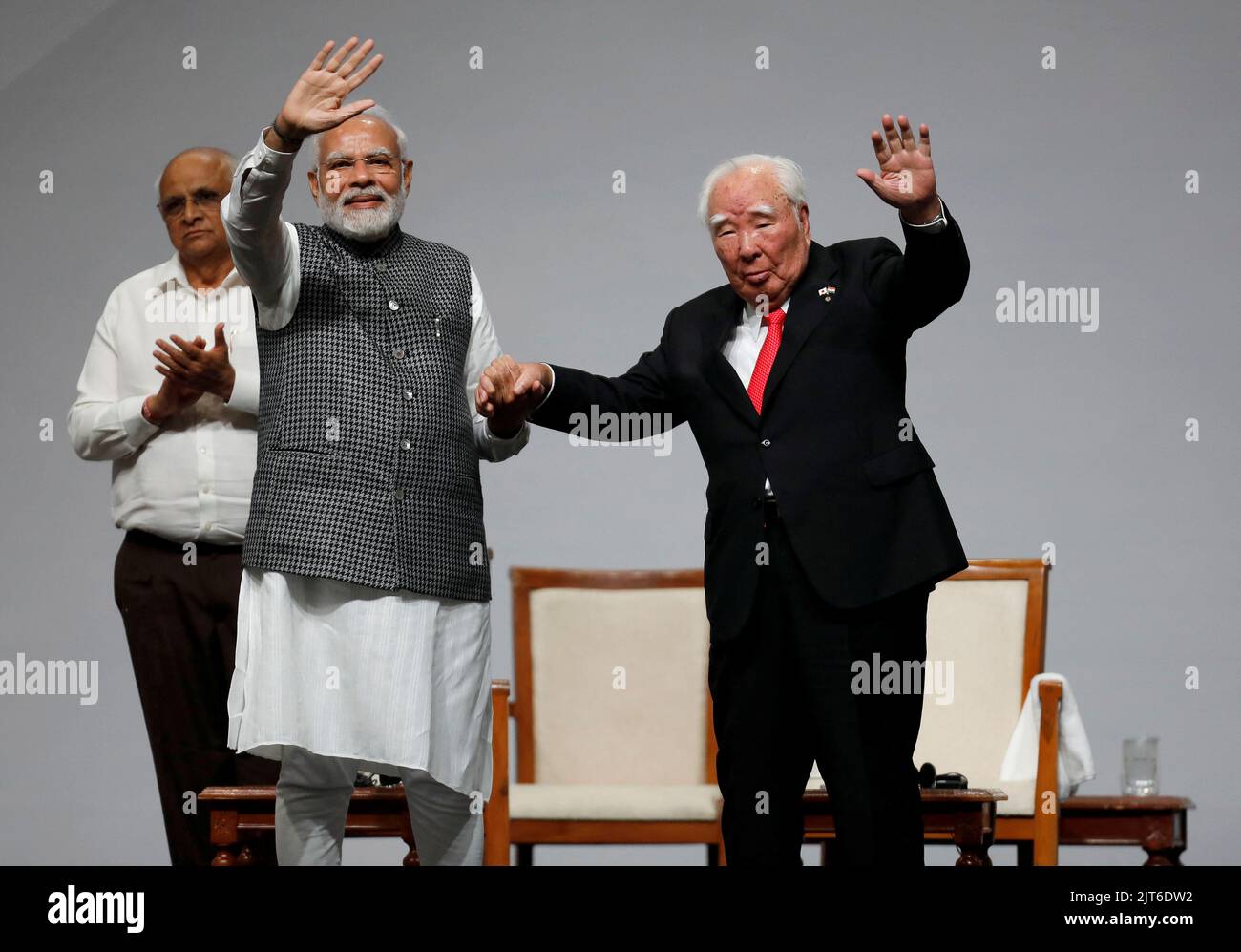India's Prime Minister Narendra Modi and Japan's Suzuki Motor Corp former chairman Osamu Suzuki wave as Chief Minister of Gujarat Bhupendra Patel applauds during an event to commemorate 40 years of Suzuki in India, in Gandhinagar, in the western state of Gujarat, India, August 28, 2022. REUTERS/Amit Dave Stock Photo
