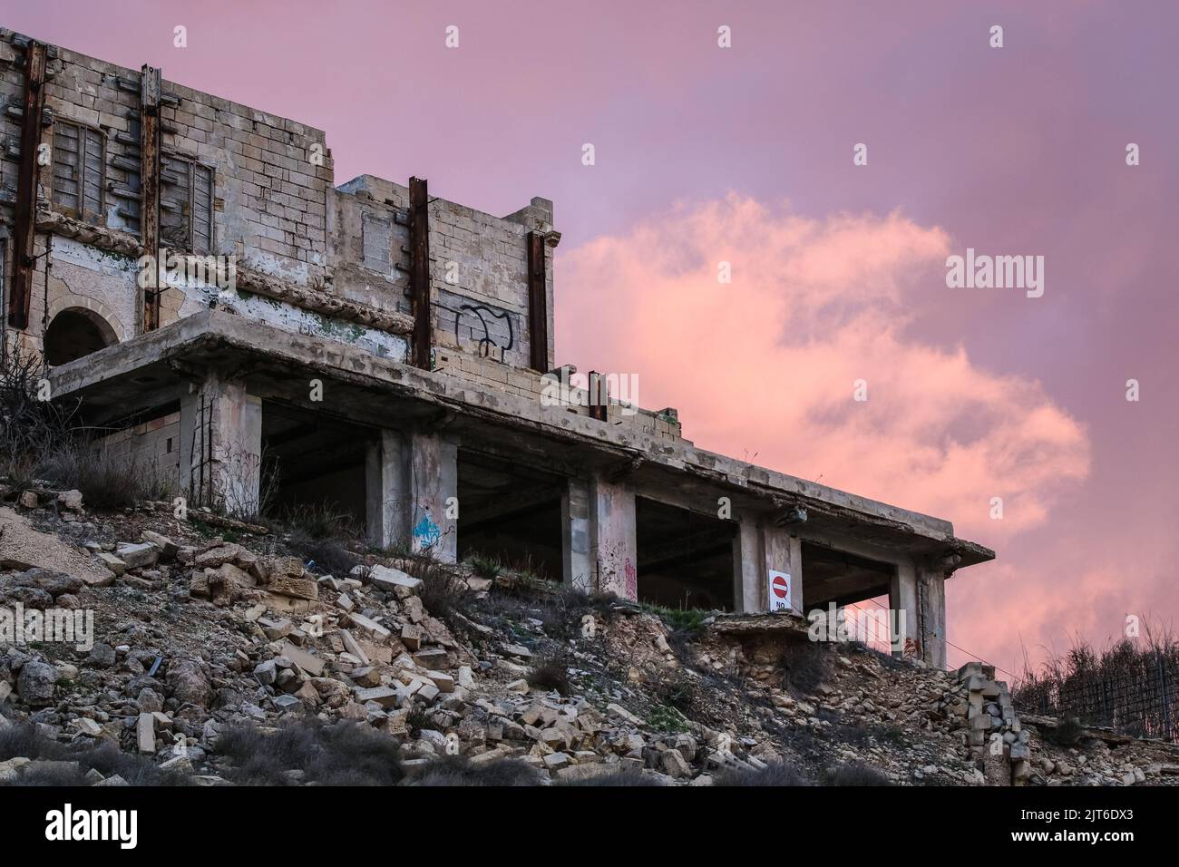 An old ruined building with broken windows and walls against a purple ...