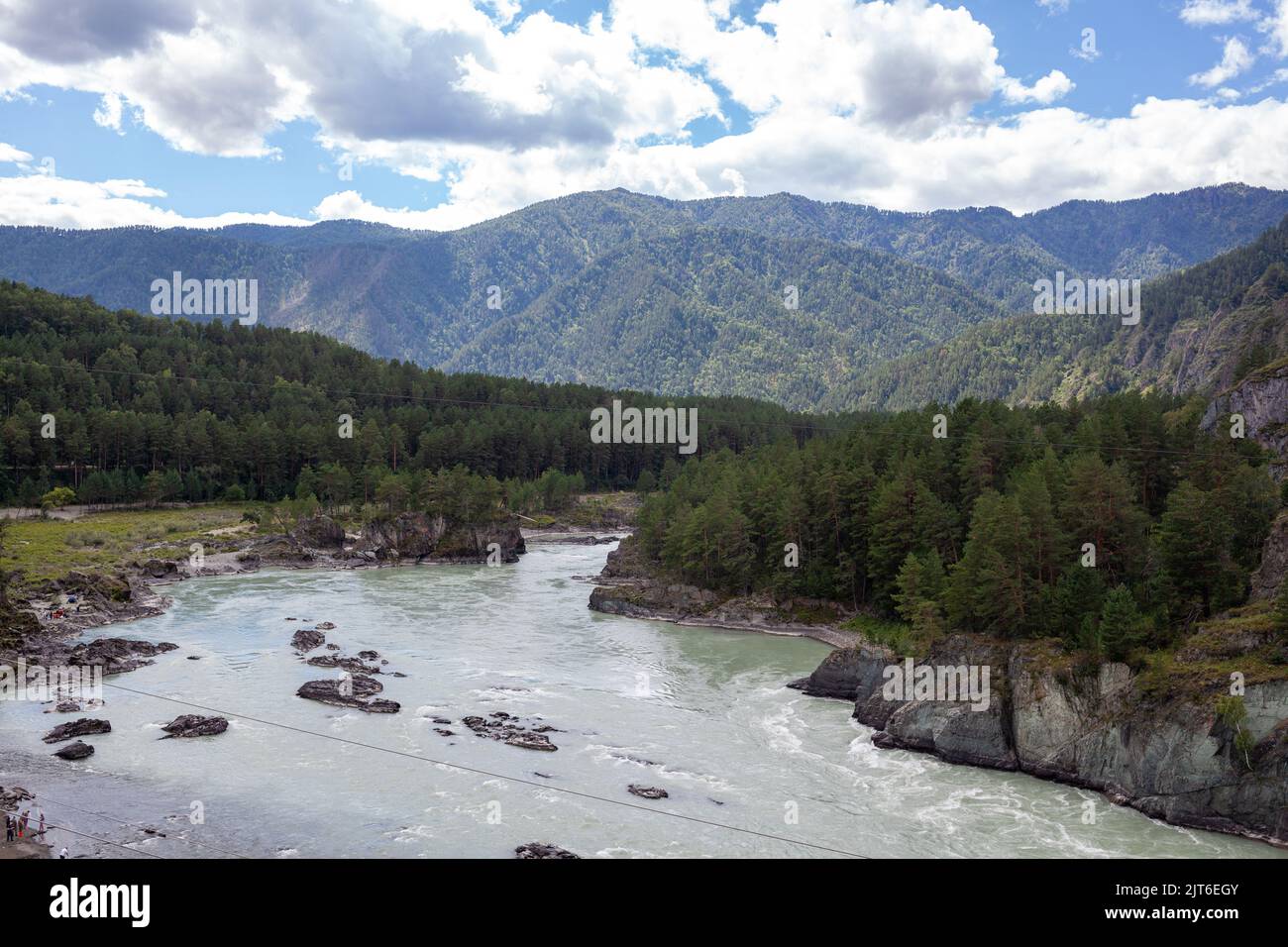 River With Large Rocks A fast-flowing wide and full-flowing mountain river. Large rocks stick ...