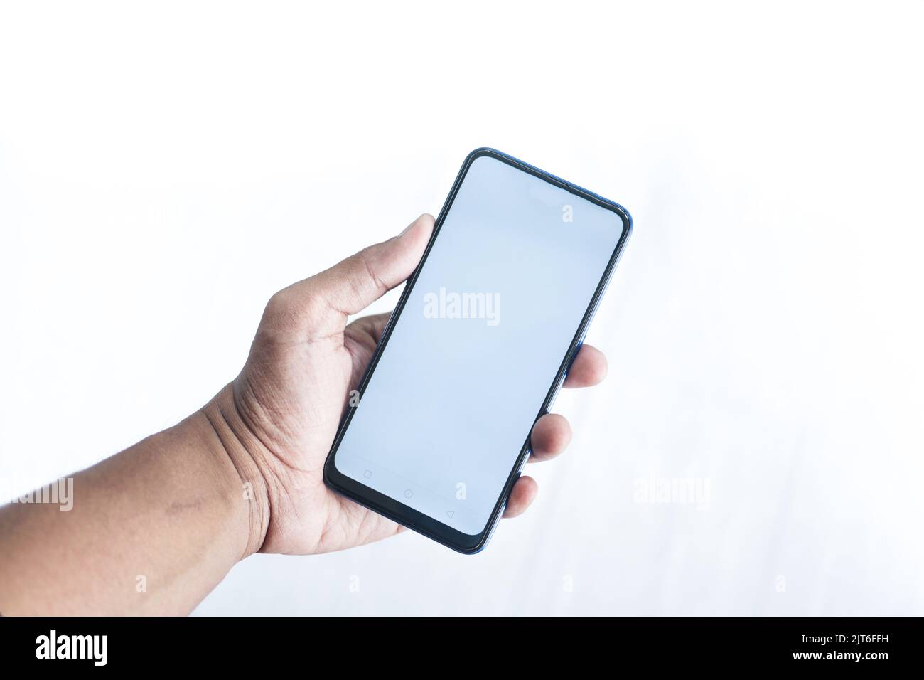 young man hand using smart phone against white wall  Stock Photo