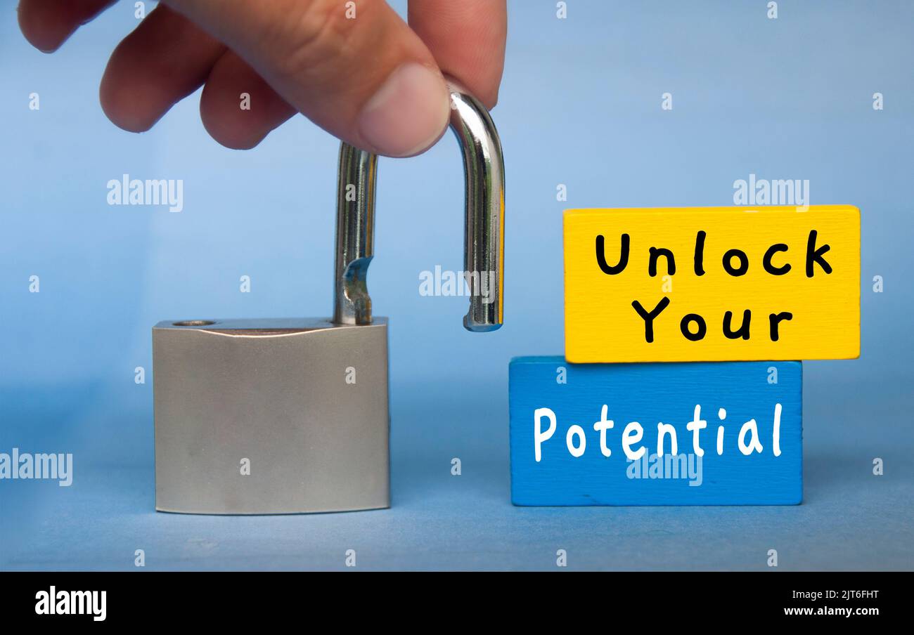 Unlock your potential text wooden blocks with hand holding padlock. Motivational concept. Stock Photo