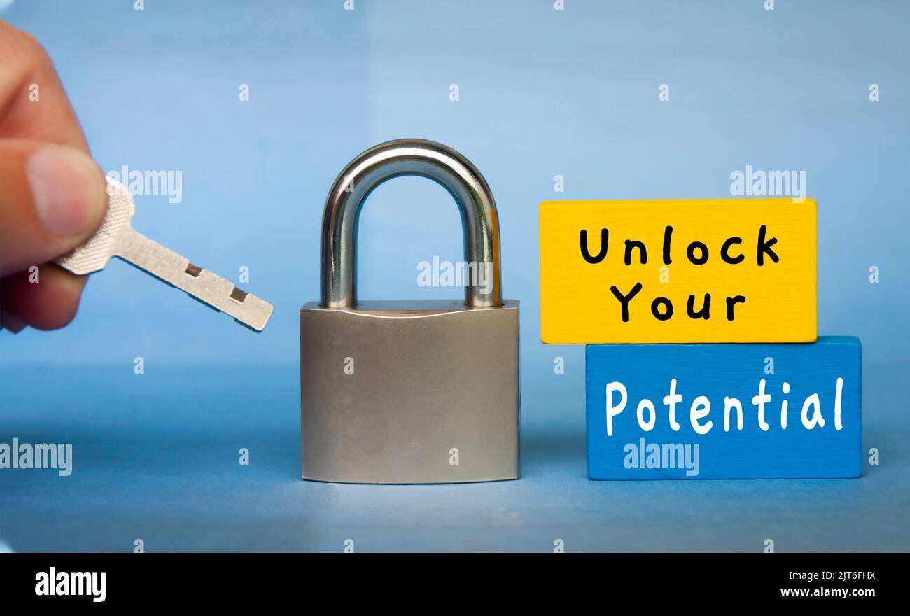 Unlock your potential text wooden blocks with hand holding key. Motivational concept. Stock Photo