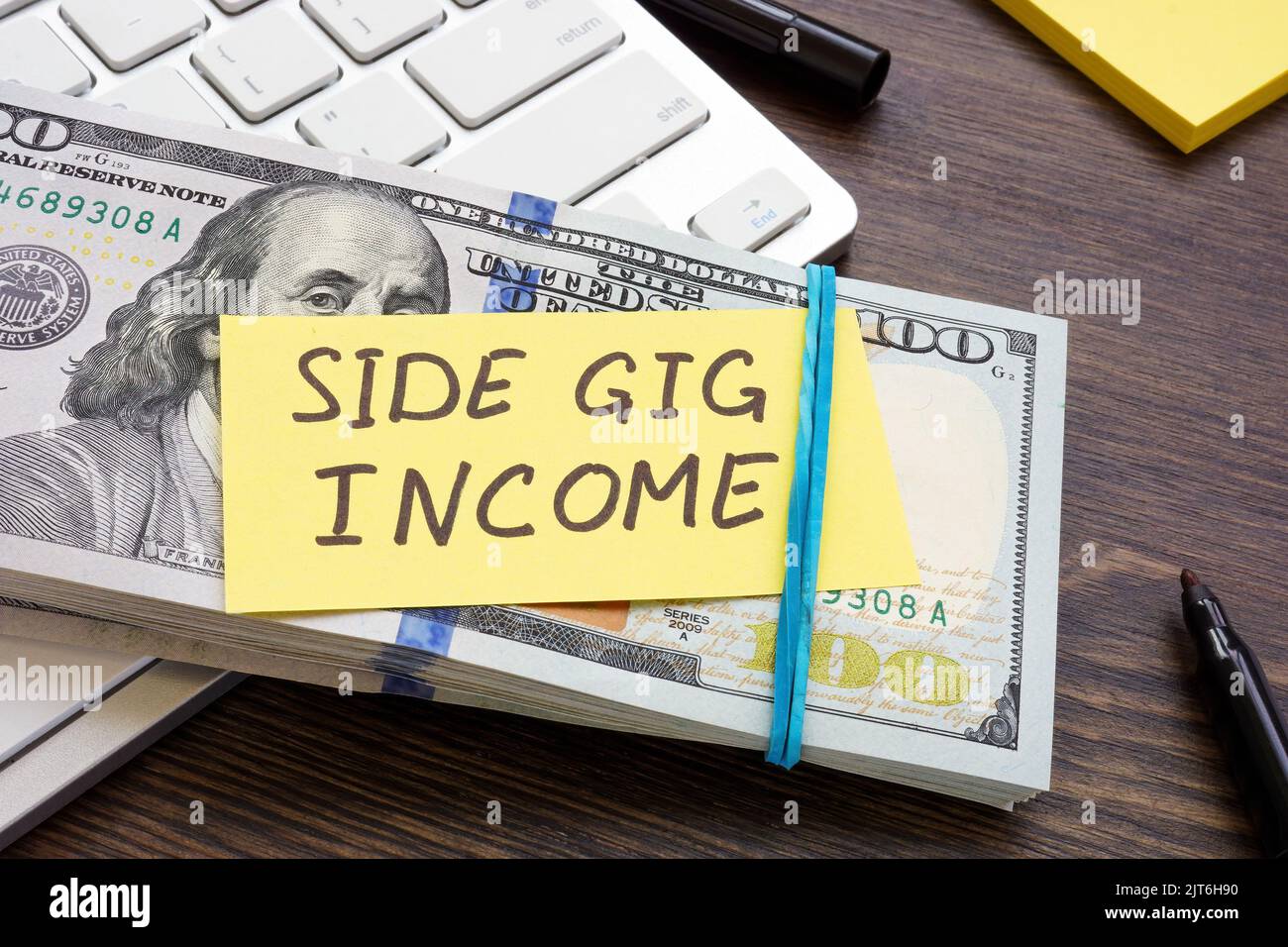 A stack of money and an inscription Side gig income on it. Stock Photo