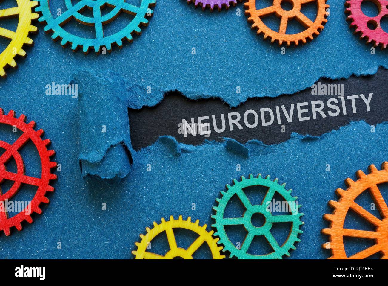 The inscription neurodiversity under the torn paper and gear wheels. Stock Photo