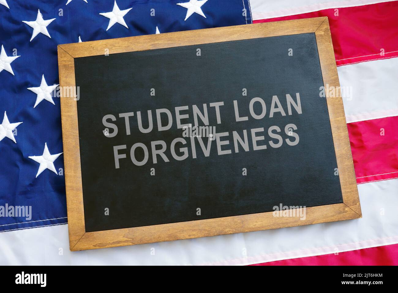 Student loan forgiveness concept. USA flag and blackboard on it. Stock Photo