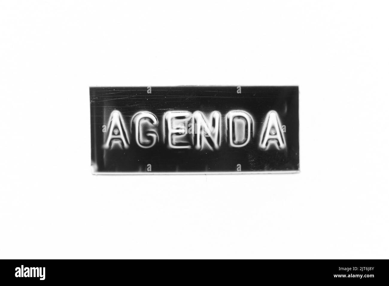 Black color banner that have embossed letter with word agenda on white paper background Stock Photo