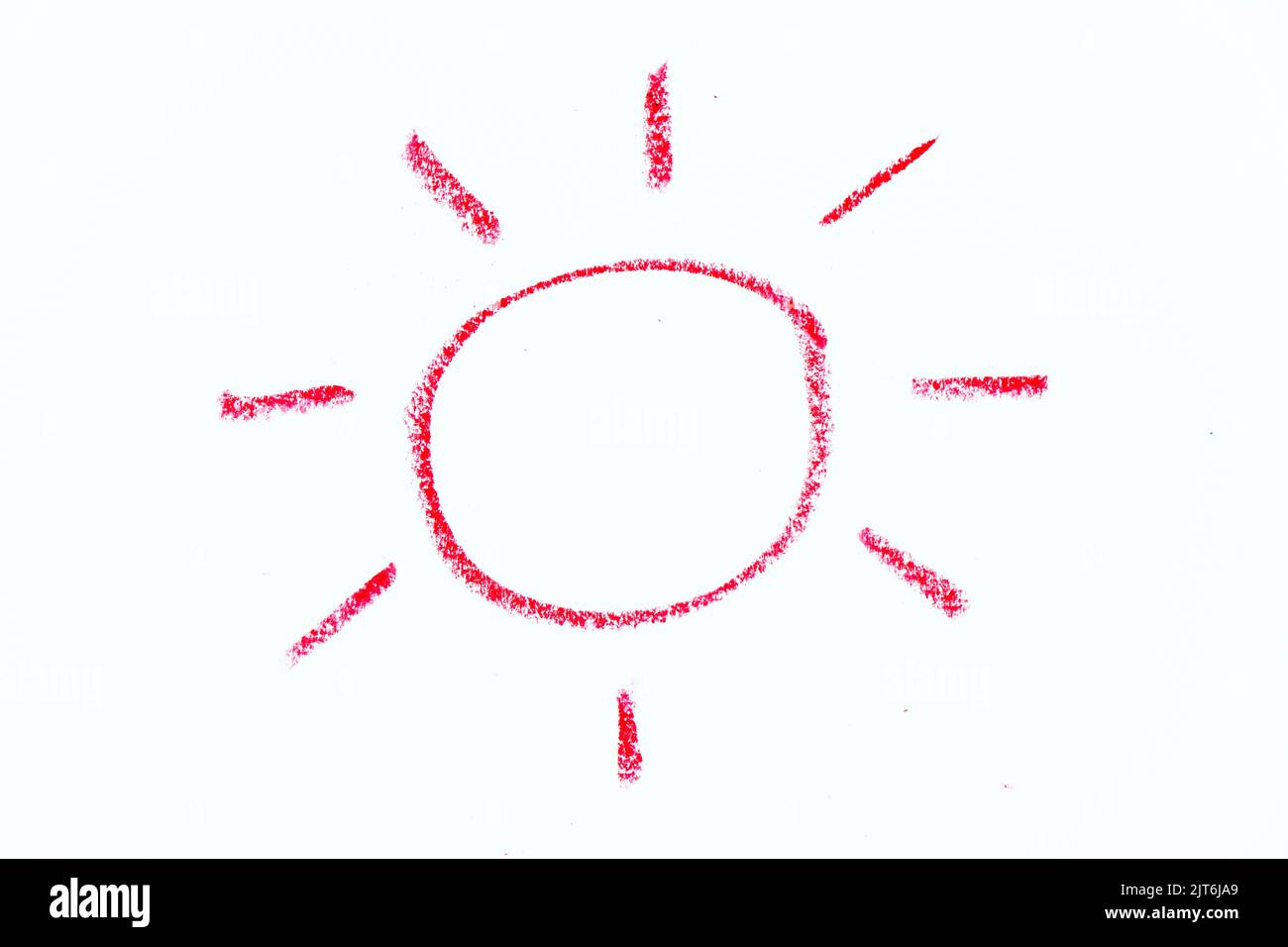 Red color oil pastel hand drawing in sun with ray shape on white paper
