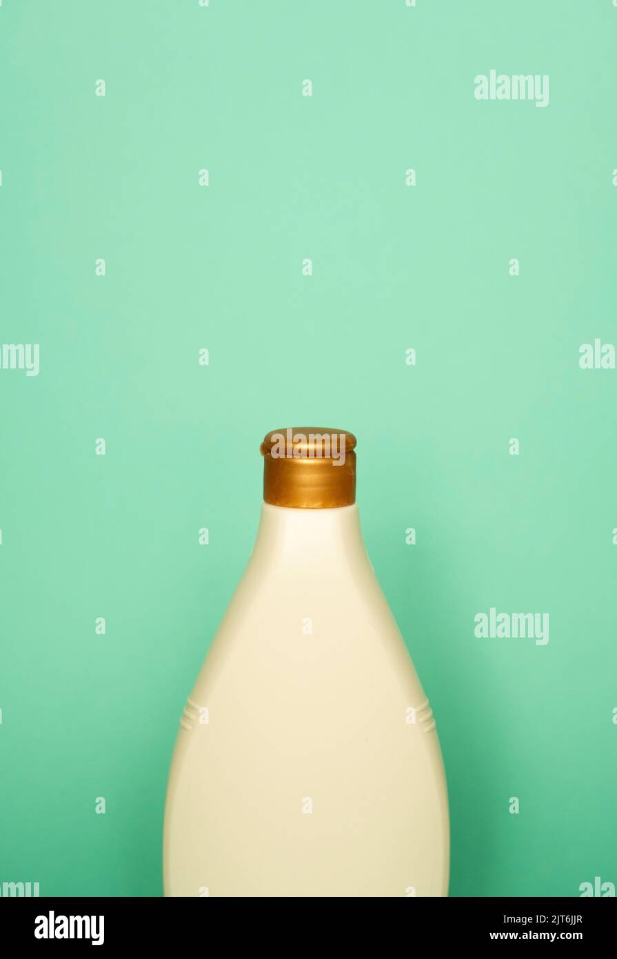 Beige blank plastic bottles isolated on green background. Stock Photo