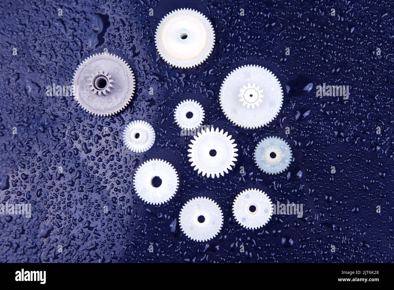 white plastic gears on a dark background. connection mechanism details