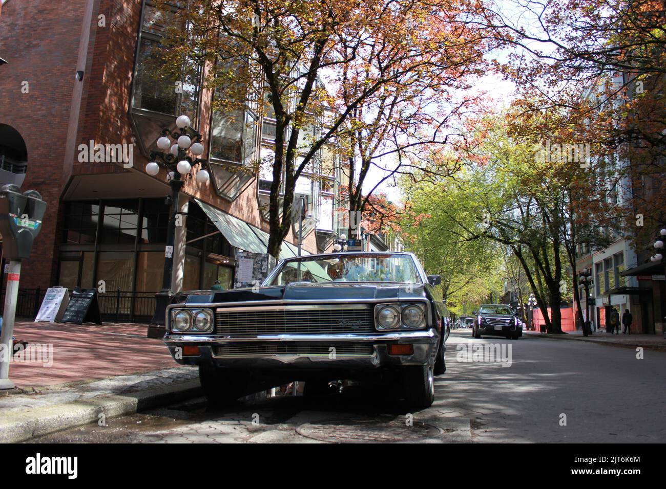 A view of a classic black car parked in downtown Vancouver, British