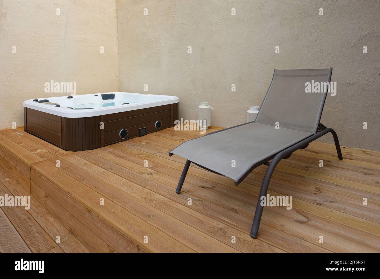 Jacuzzi and deck chair on wooden floor in a house. Stock Photo