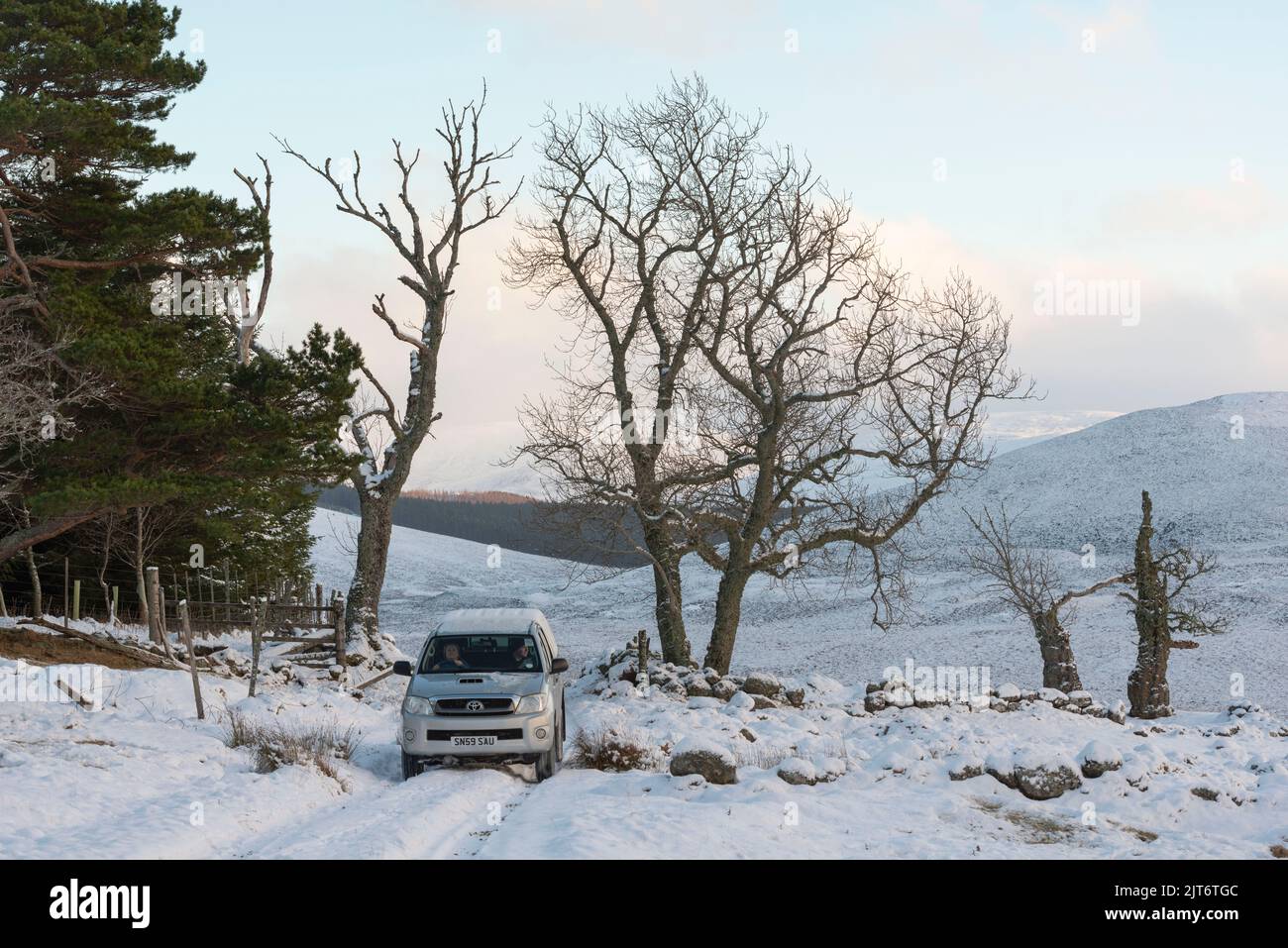 A Pickup Truck on a Snow-covered Trail at the Top of Glen Girnock in the Cairngorms National Park in Winter Stock Photo