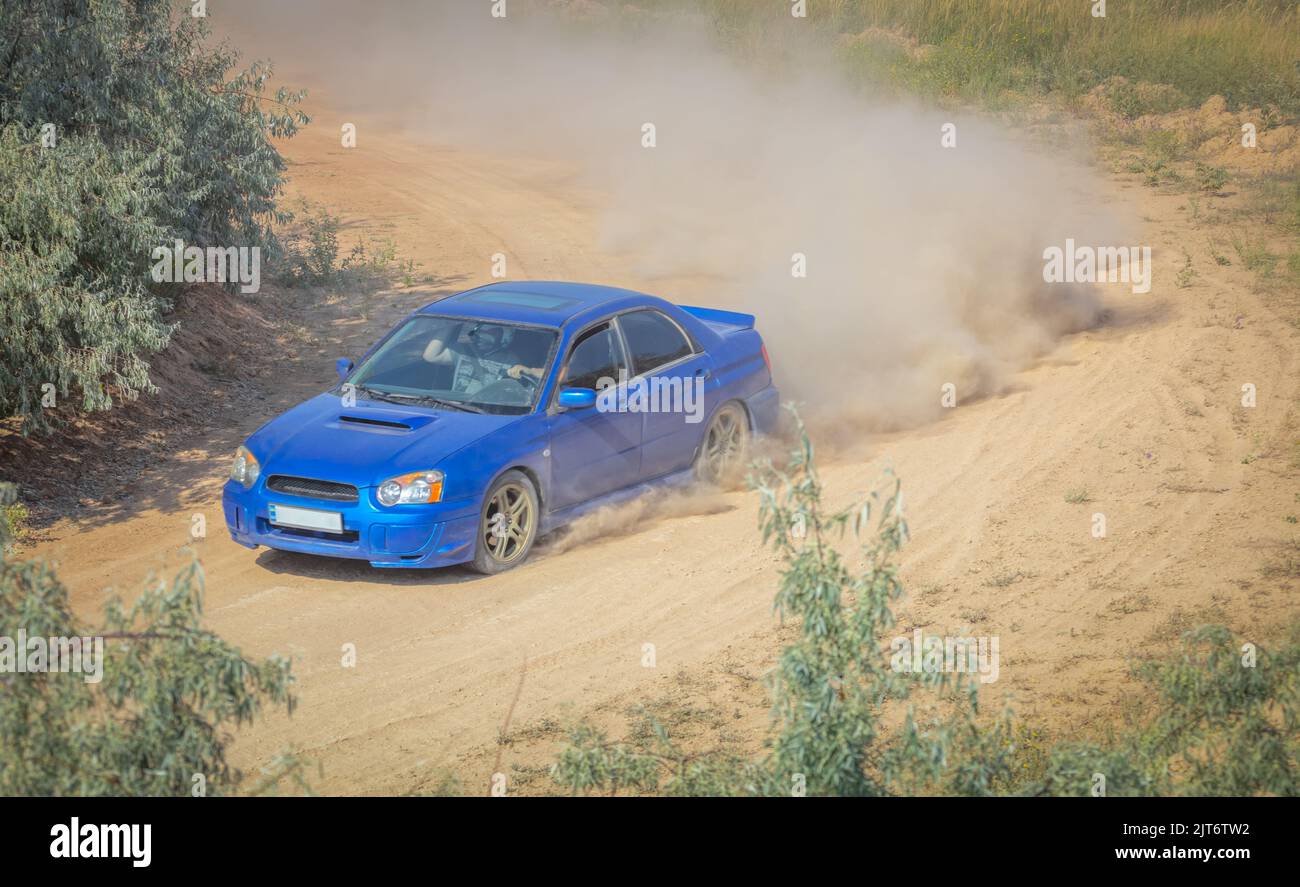Sunny summer day. Dusty rally track. Sports car does a lot of dust in ...