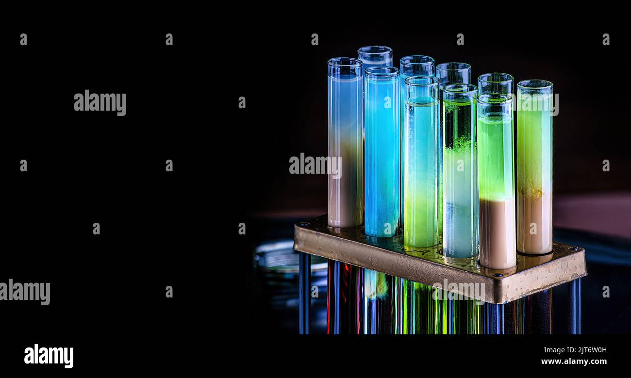 Colorful shot drinks in glass tubes. Dark background, atmospheric bar