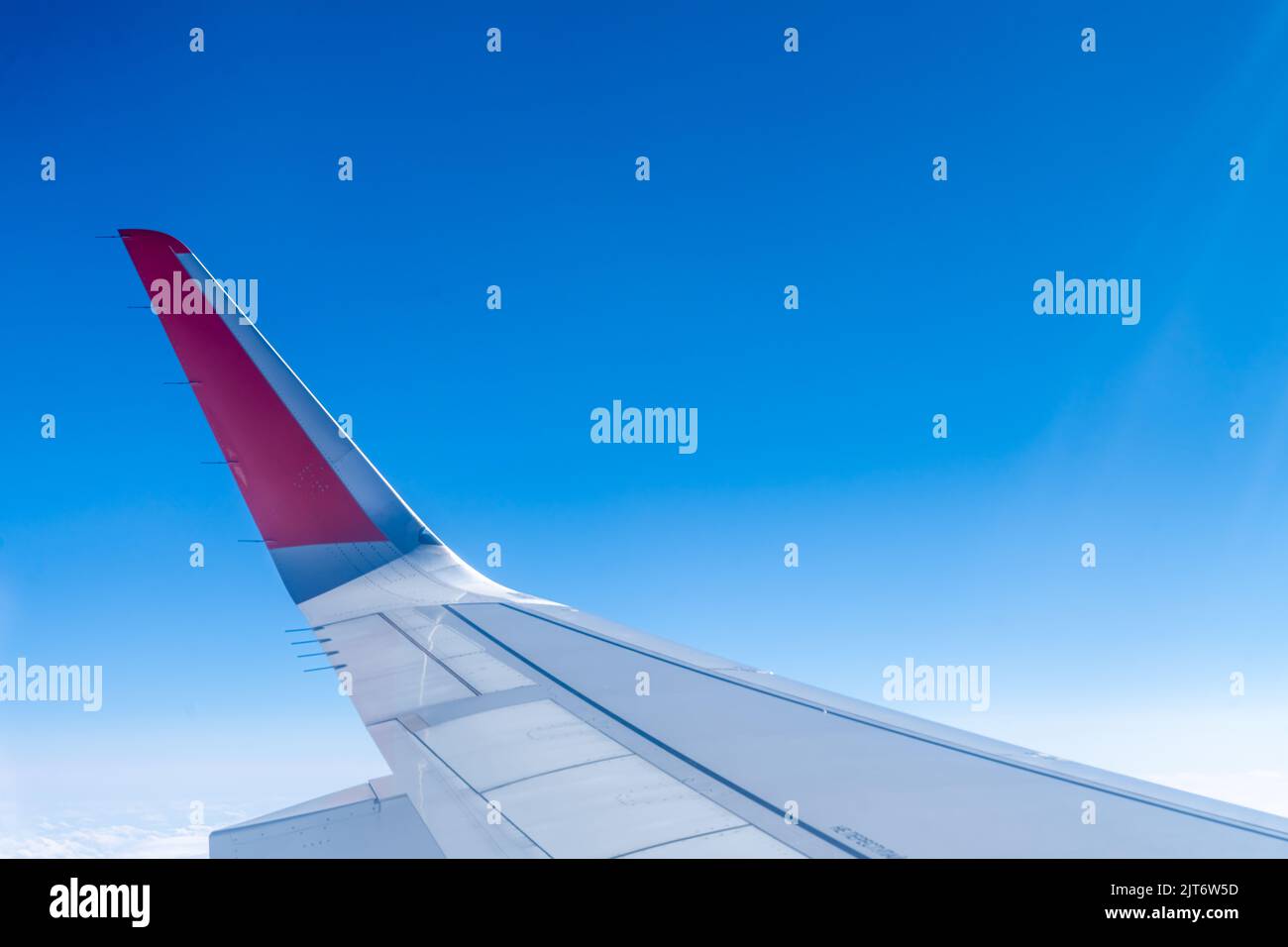 the wing of the aircraft against the sky and white clouds Stock Photo ...