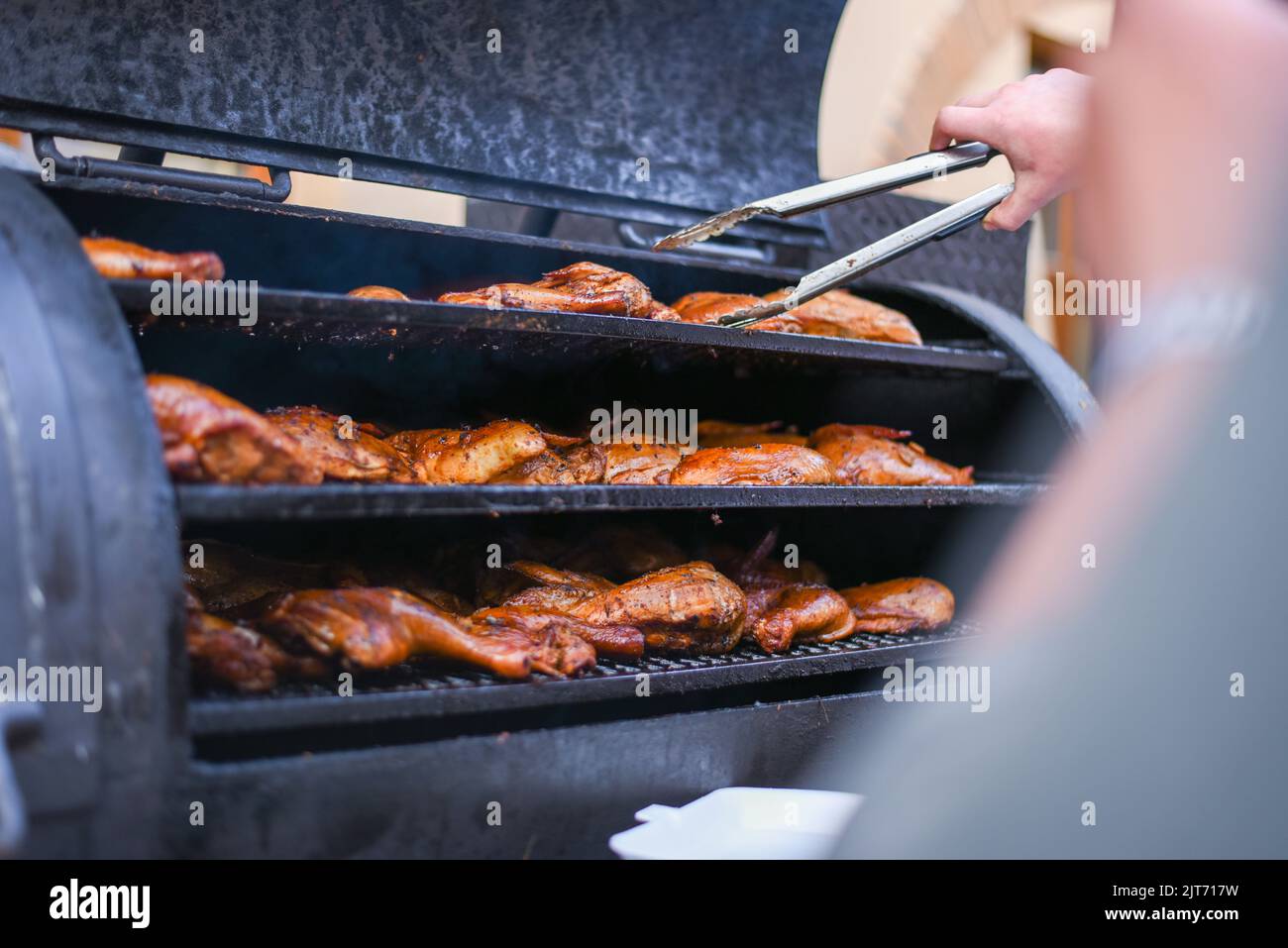 Grilling whole delicious duck in rotisserie machine, closeup Stock