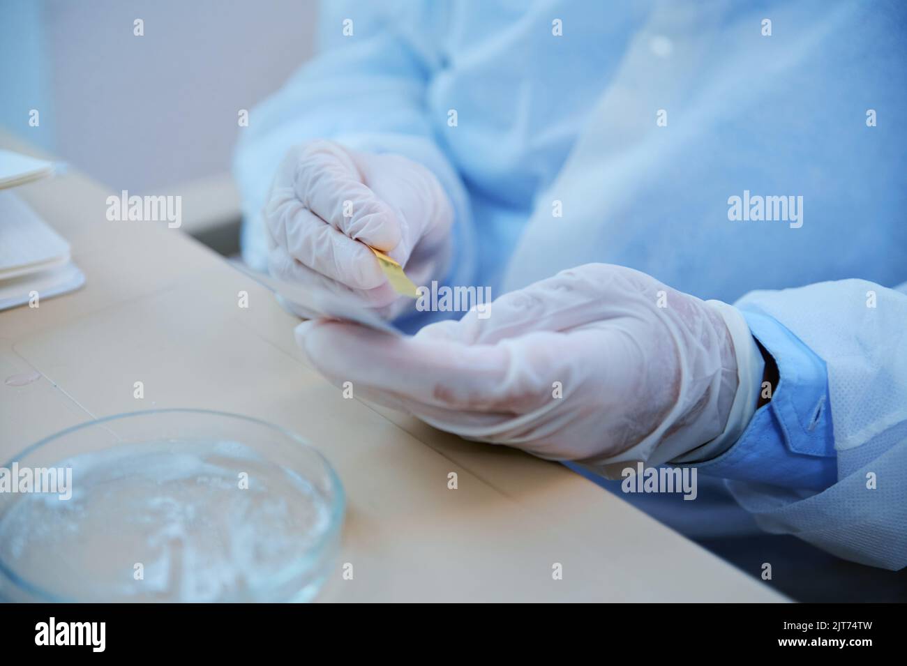 Hands of chemist using litmus paper conduct PH test in a medical