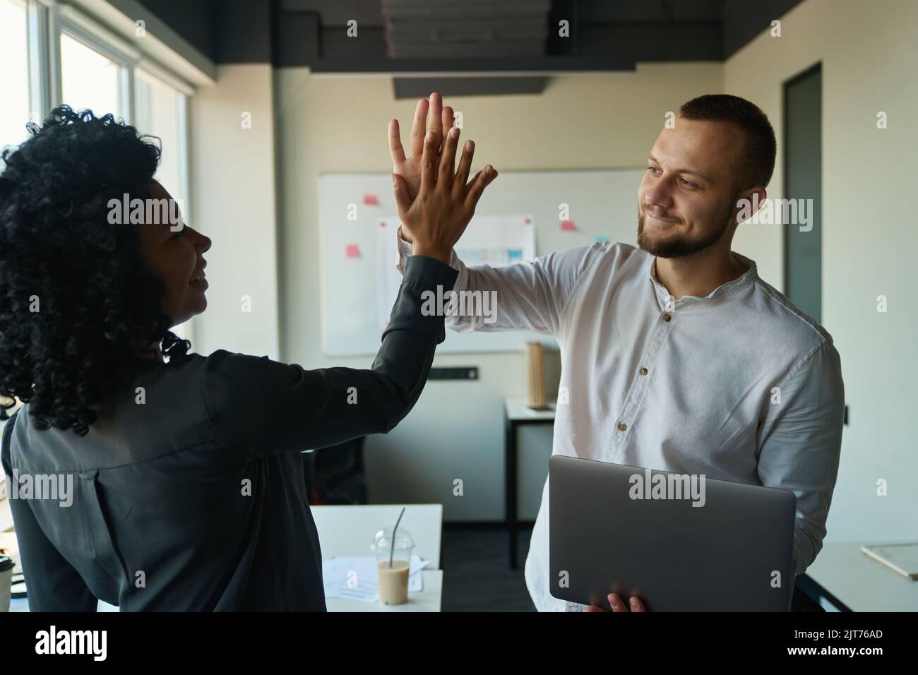 Joyful man and woman give five for project victory Stock Photo