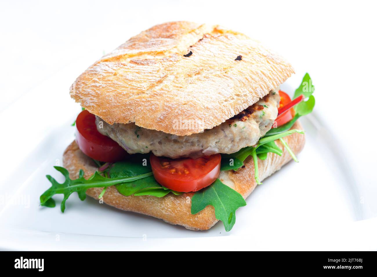 homemade turkey burger with cherry tomatoes and arugula in ciabatta