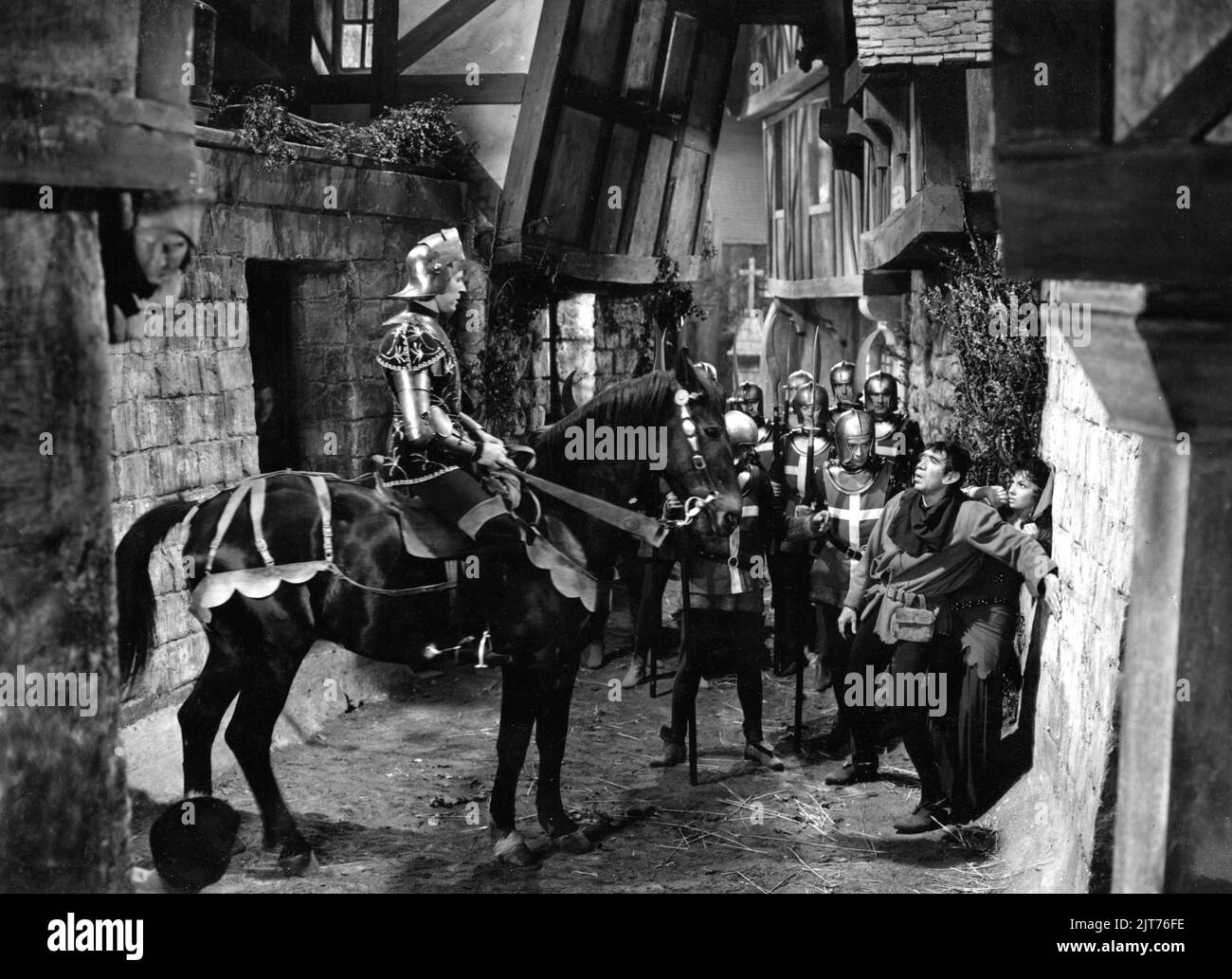 ANTHONY QUINN as Quasimodo and GINA LOLLOBRIGIDA as Esmeralda with Soldiers on Paris Street in THE HUNCHBACK OF NOTRE DAME / NOTRE DAME DE PARIS 1956 director JEAN DELANNOY novel Victor Hugo adaptation / dialogue Jean Aurenche and Jacques Prevert music Georges Auric costume design Georges Benda production design Rene Renoux choreographer Leonid Massine producers Raymond and Robert Hakim France - Italy co-production Paris Film Productions / Panitalia Stock Photo
