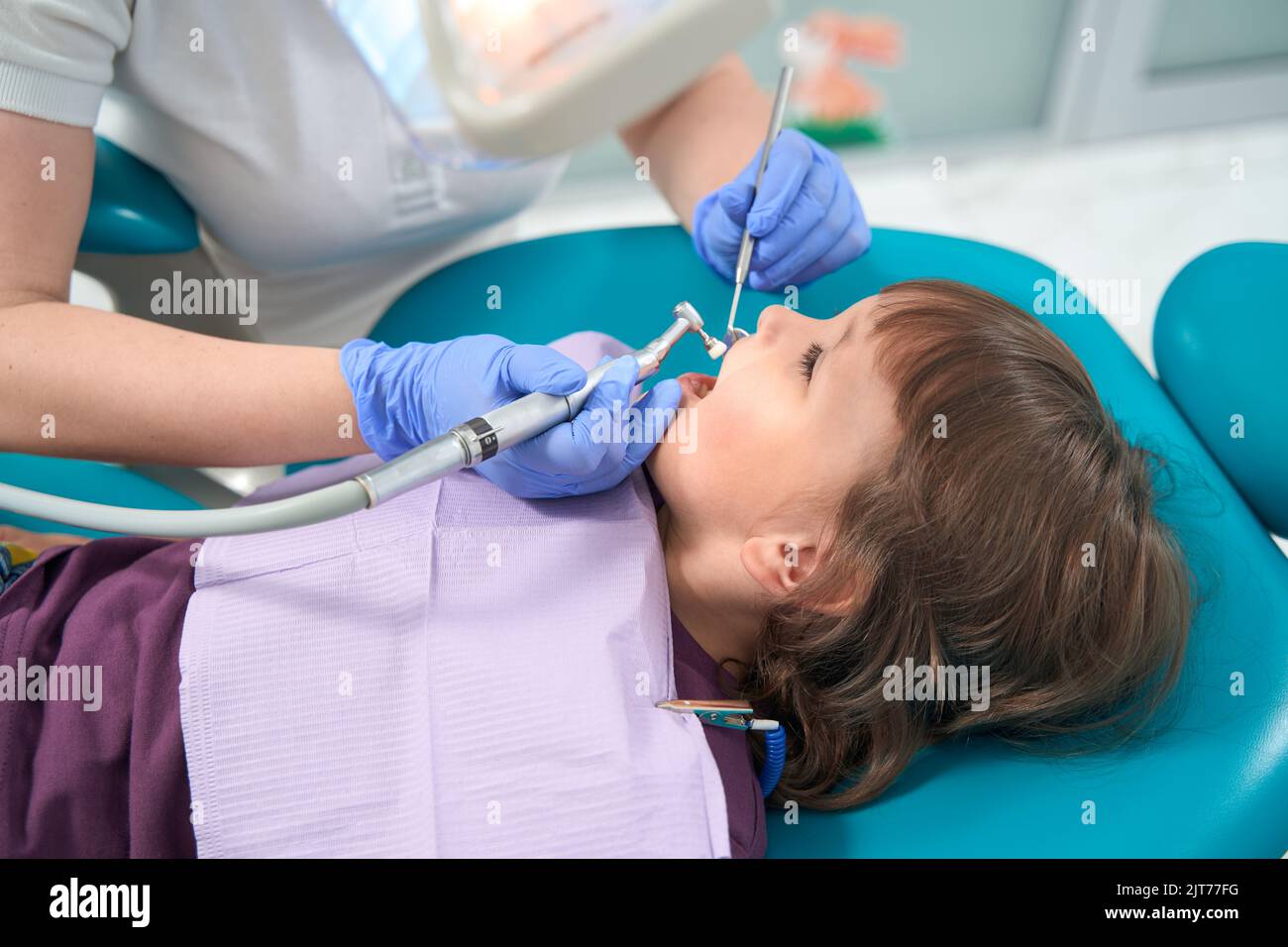 Dental hygienist conducting teethpolishing procedure on little girl Stock Photo Alamy