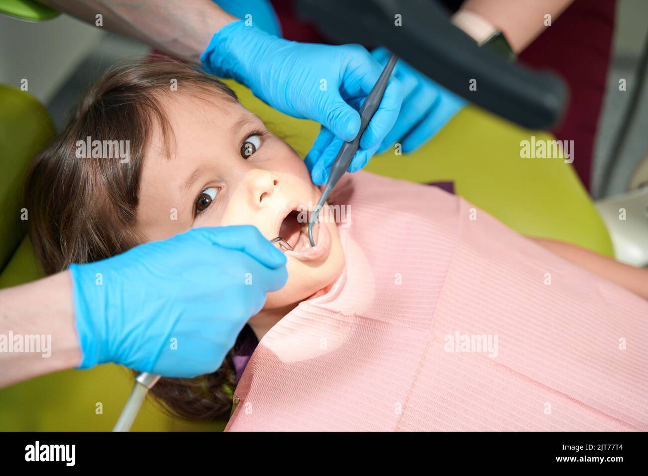 Pediatric dentist performing examination of female child teeth Stock Photo