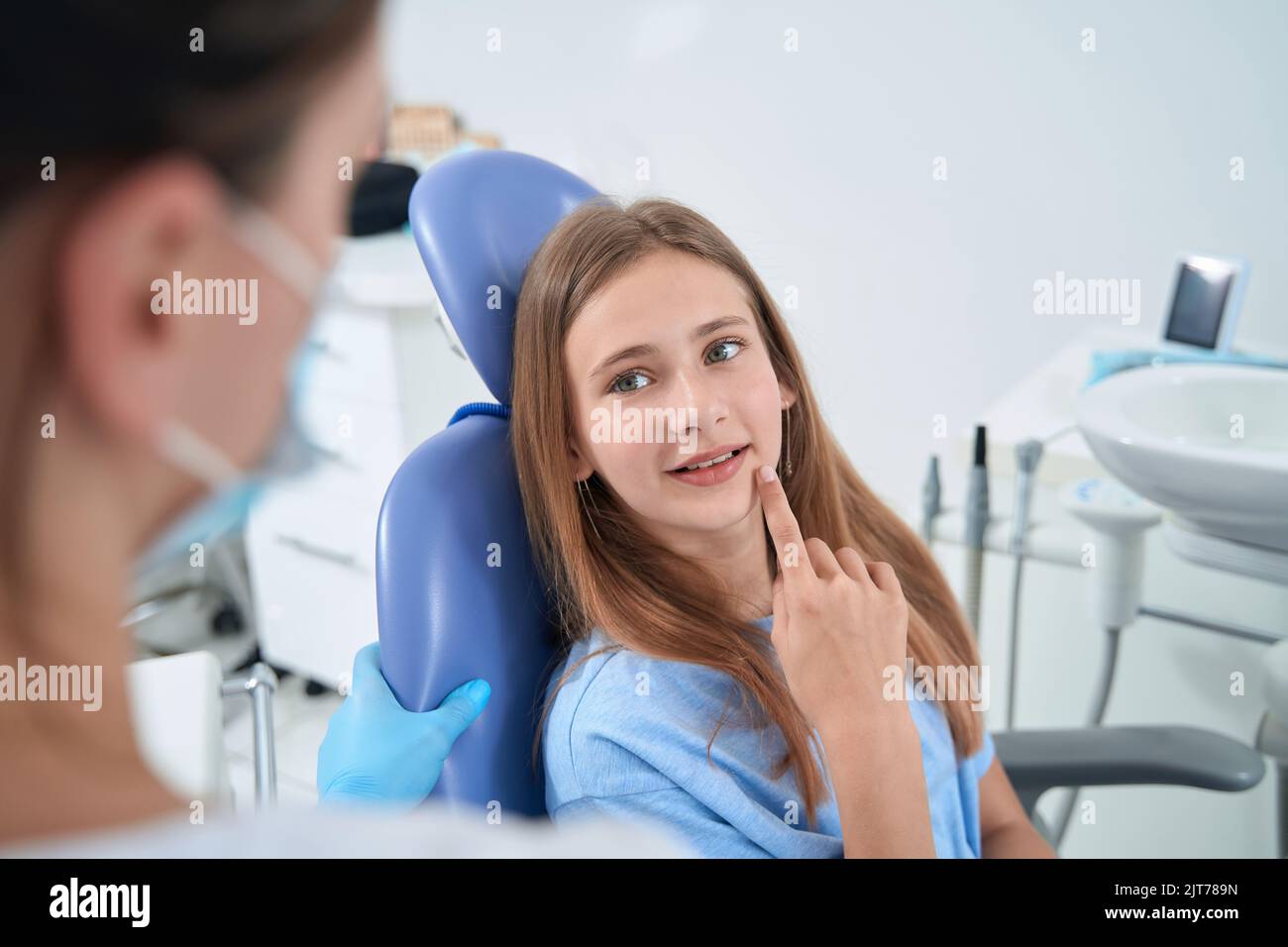 Teenage patient communicating with pedodontist during consultation Stock Photo