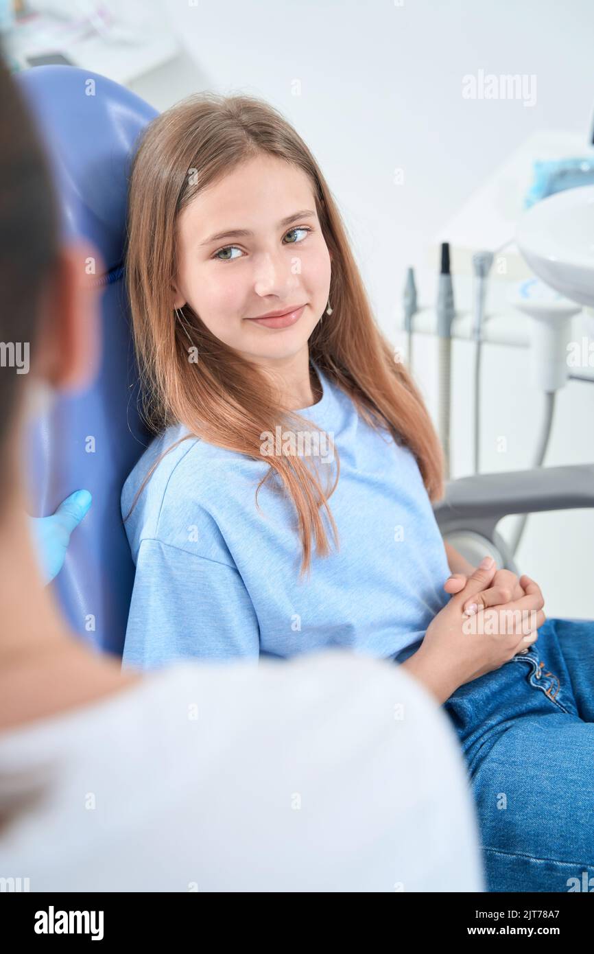 Teenage patient listening to her pediatric dentist Stock Photo