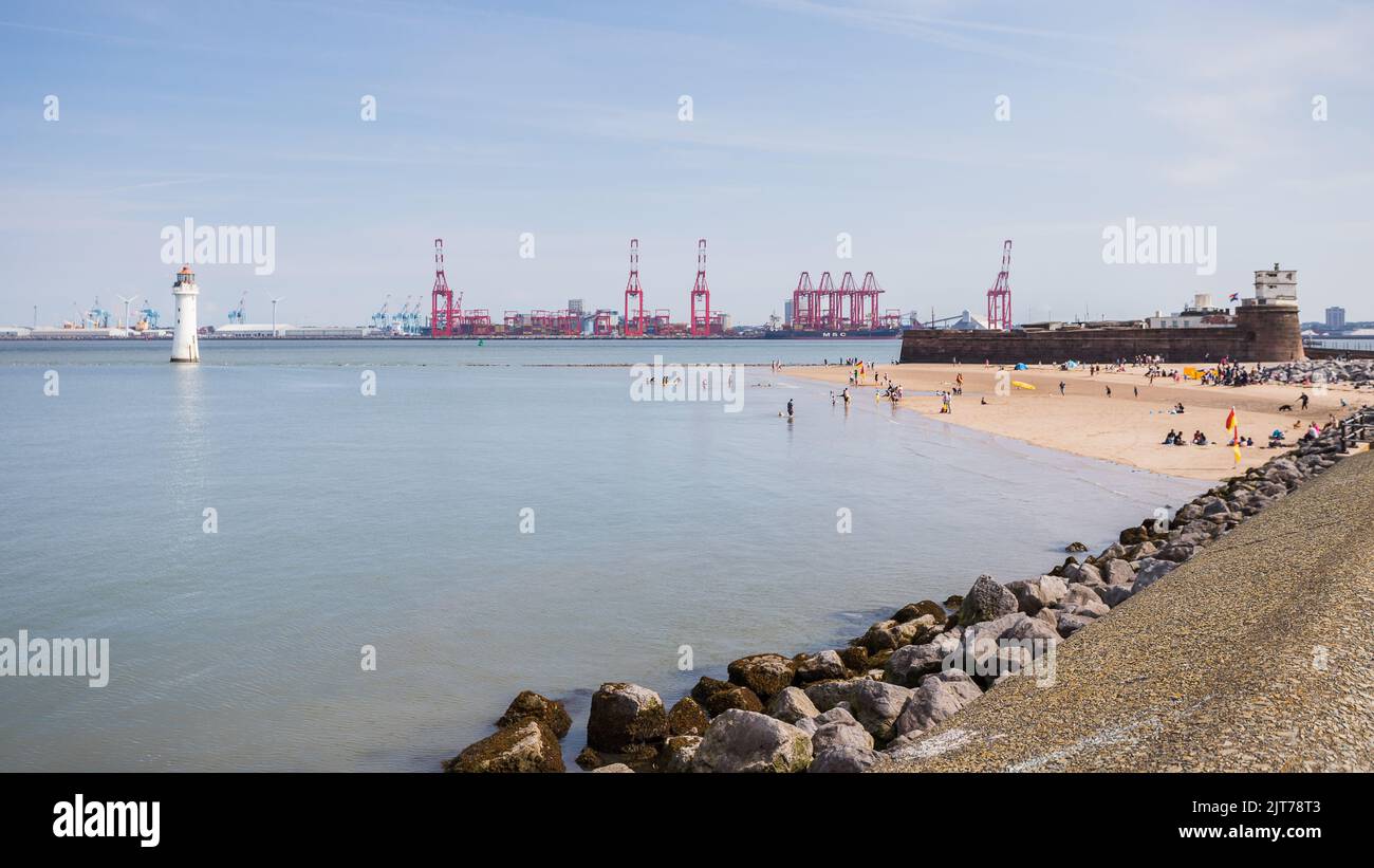 Locals seen enjoying a small area of beach at New Brighton as the tide comes in on the Wirral peninsula in August 2022. Stock Photo