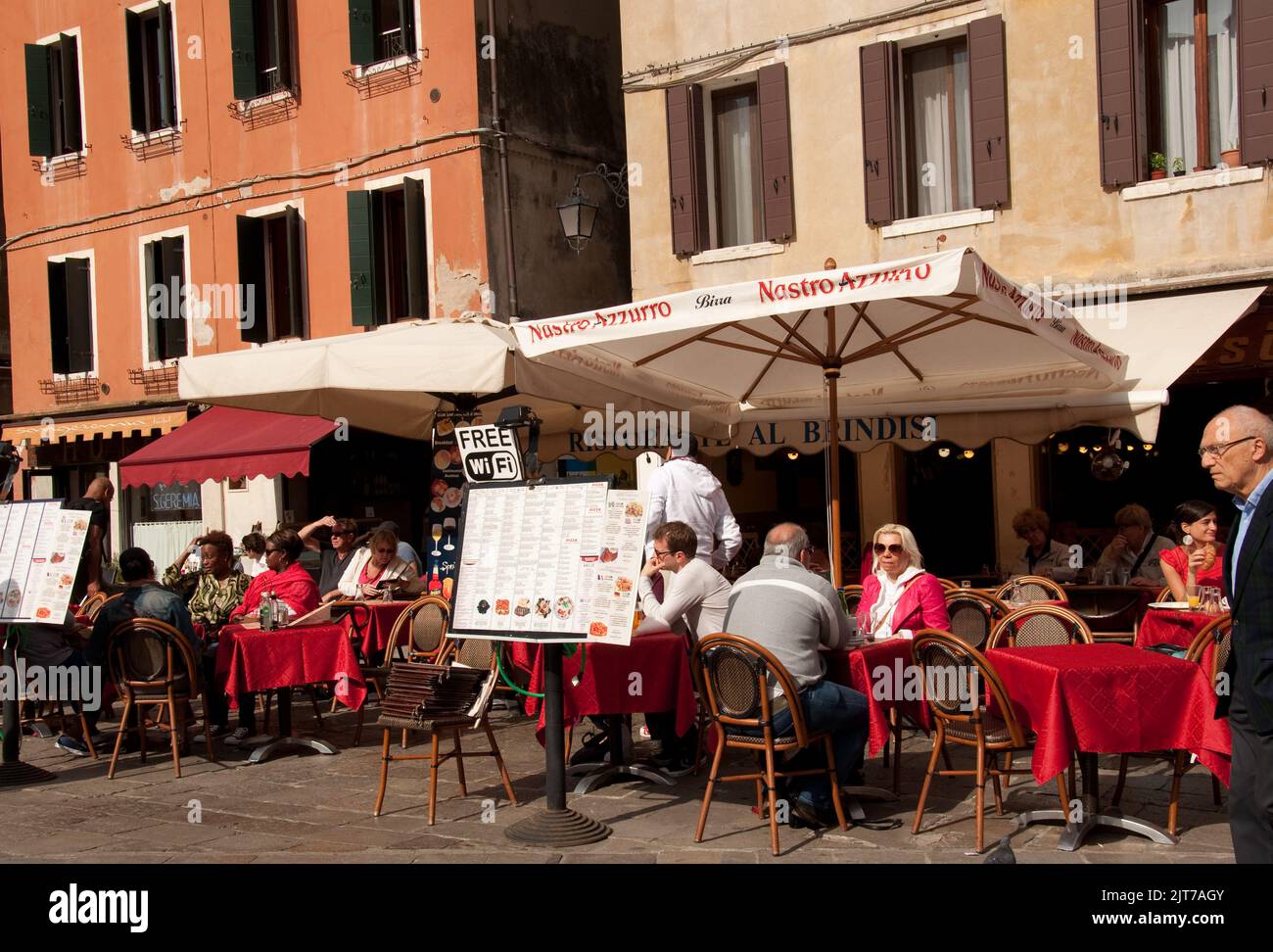 Street Scene and Restaurant, Venice, Italy.  People eating, drinking and chatting in a pavement cafe - enjoying the last days of Summer Stock Photo