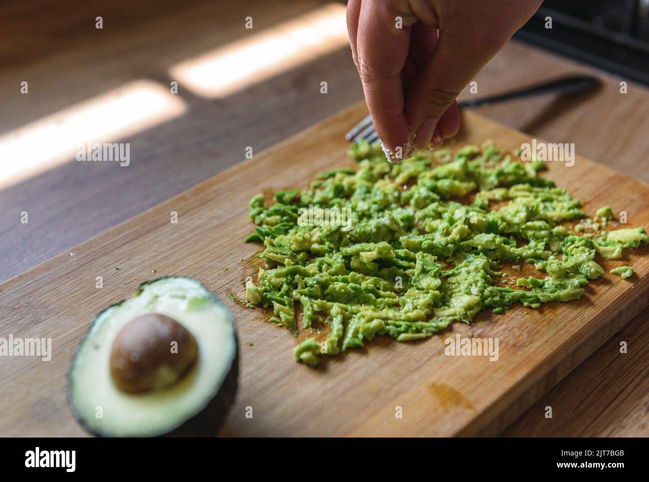 A woman adding salt to avocado Stock Photo - Alamy
