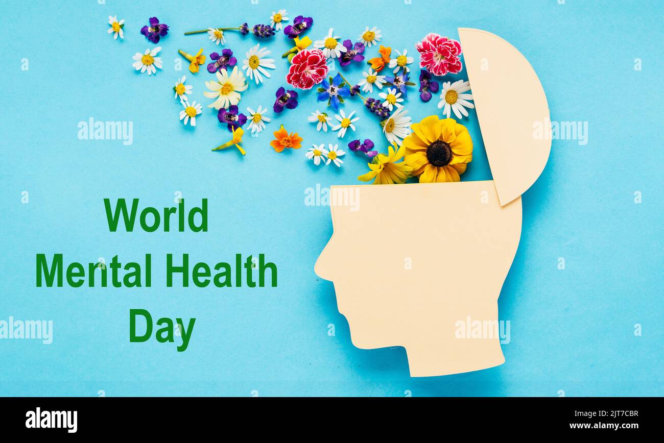World mental health day concept. Human head symbol and flowers on blue