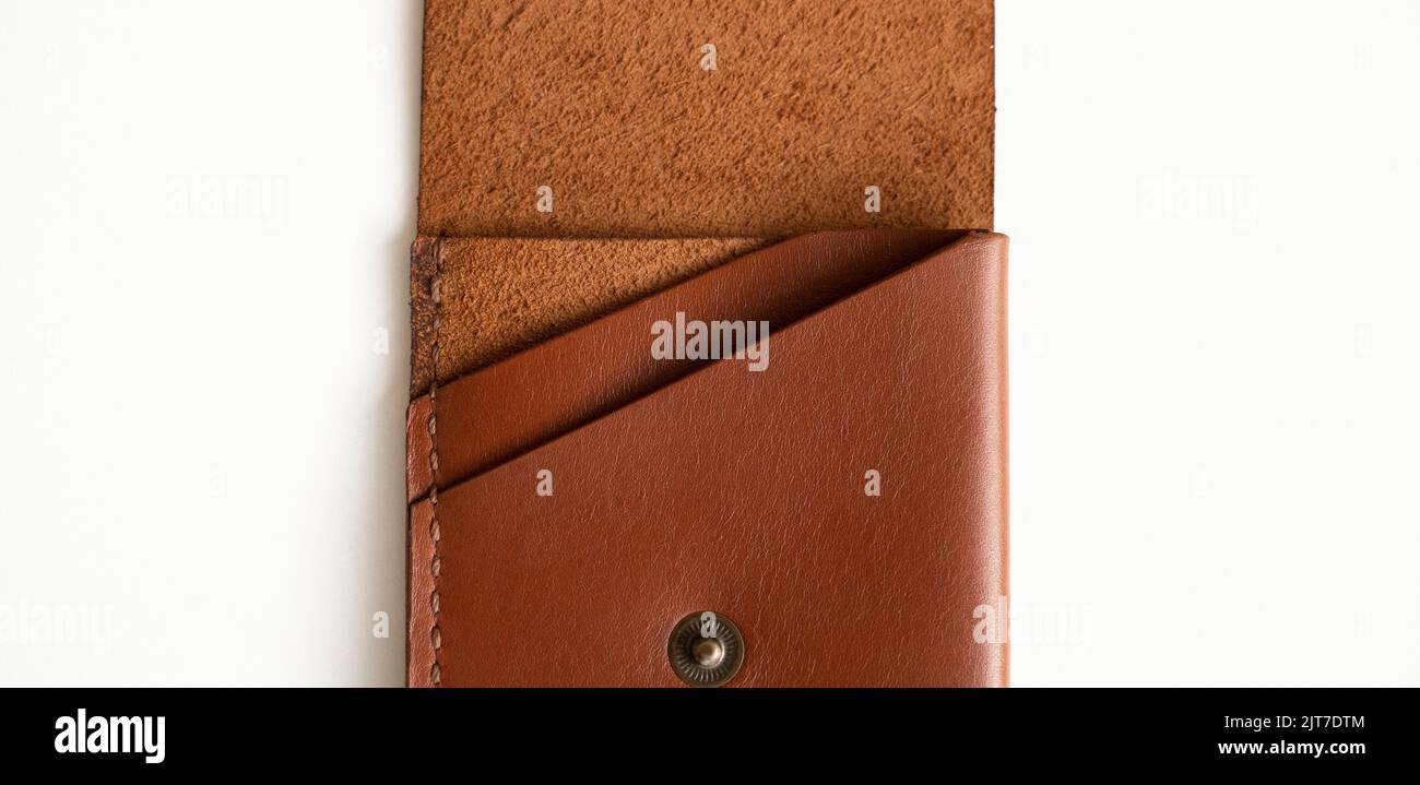 Opened empty orange genuine leather card holder on a white surface. Stock Photo