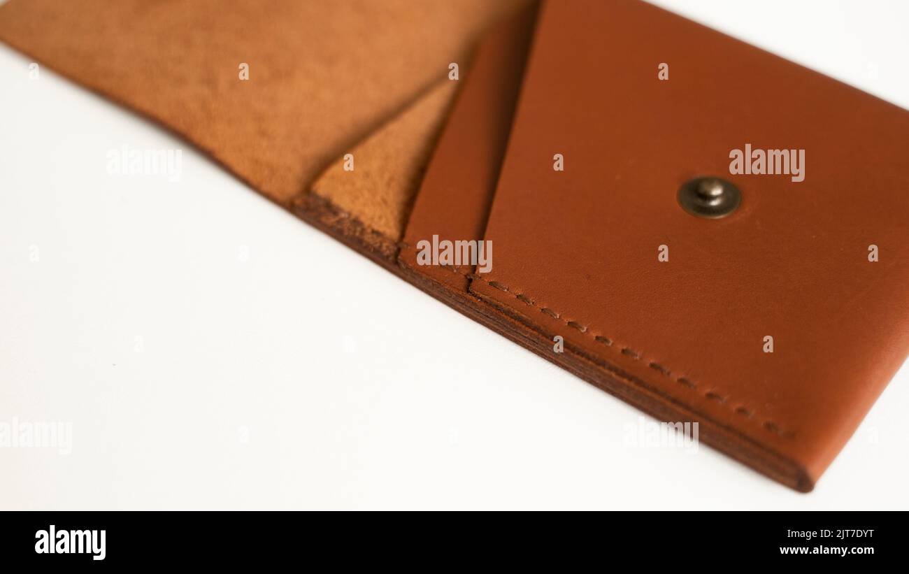 Opened empty orange genuine leather card holder on a white surface. Stock Photo