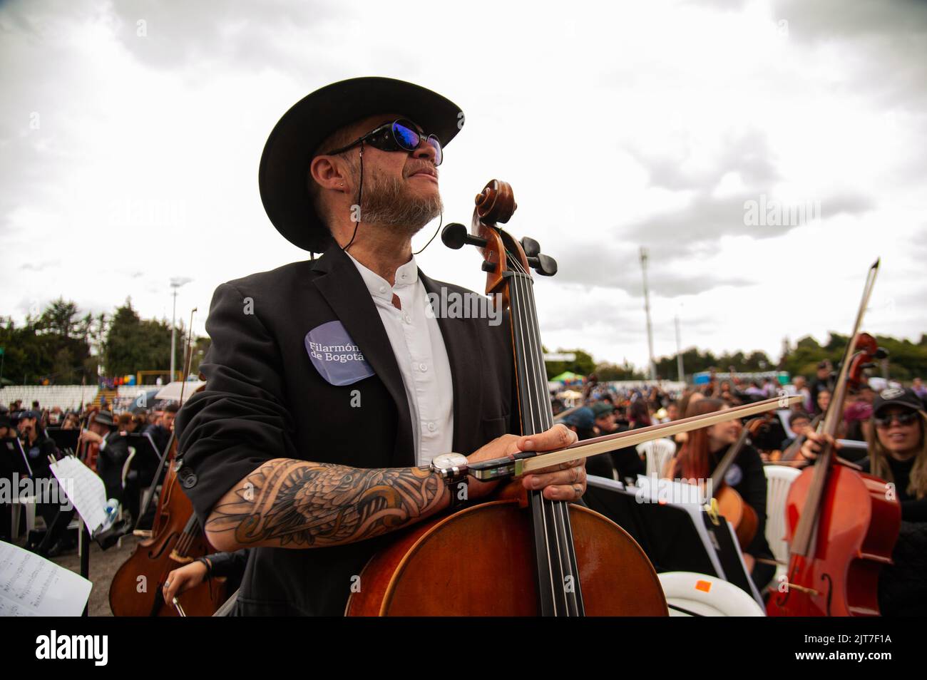 Bogota, Colombia. 28th Aug, 2022. A cello player poses for a photo showing his tattoos during the world's largest concert for peace played by Bogota's Symphonic Orchrestra and children, in Bogota, Colombia on August 28, 2022. Photo by: Chepa Beltran/Long Visual Press Credit: Long Visual Press/Alamy Live News Stock Photo