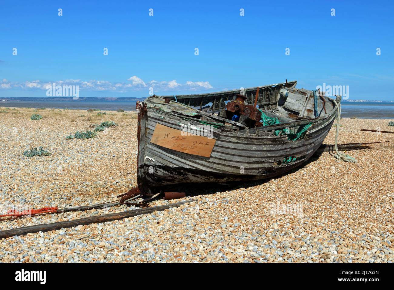Old fishing boat on the shingle beach at Dungeness Kent UK Stock Photo