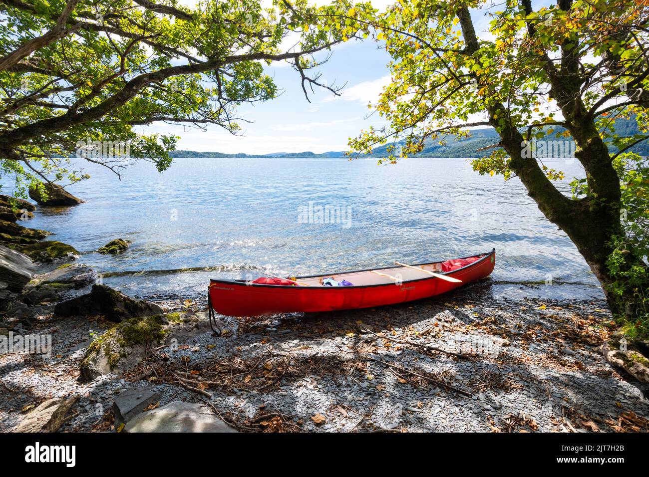 Canoe on small slate beach, Loch Lomond, Scotland, UK Stock Photo