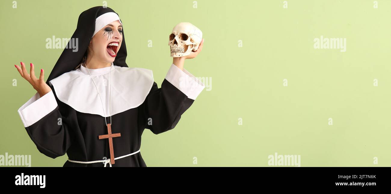 Woman dressed for Halloween as nun with skull on green background with space for text Stock Photo