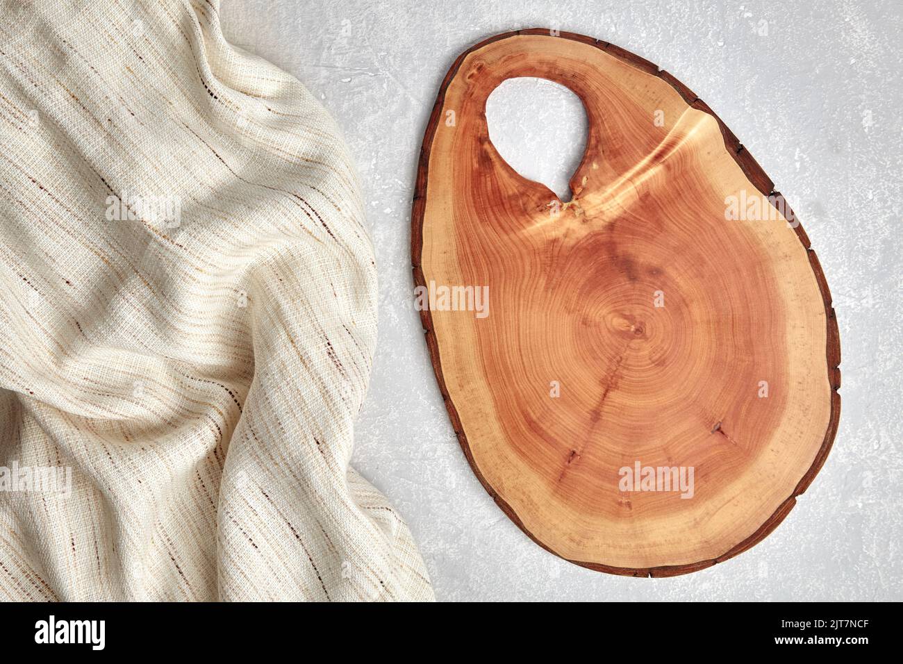 Cutting board and coasters on a gray concrete table with a kitchen towel. Food display template. Top view with copy space Stock Photo