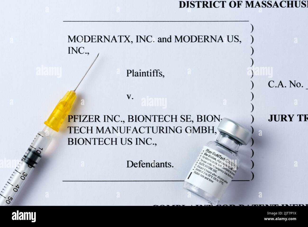 Moderna vs Pfizer Biontech legal battle concept. Real PFIZER vaccine vial and syringe placed on printed Moderna's COMPLAINT FOR PATENT INFRINGEMENT. S Stock Photo