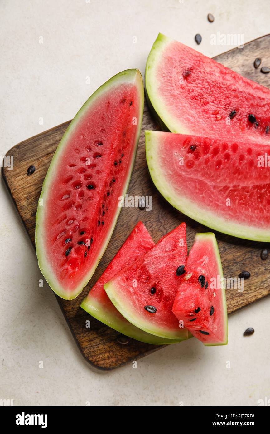 Cutting board with slices of watermelon on white background Stock Photo