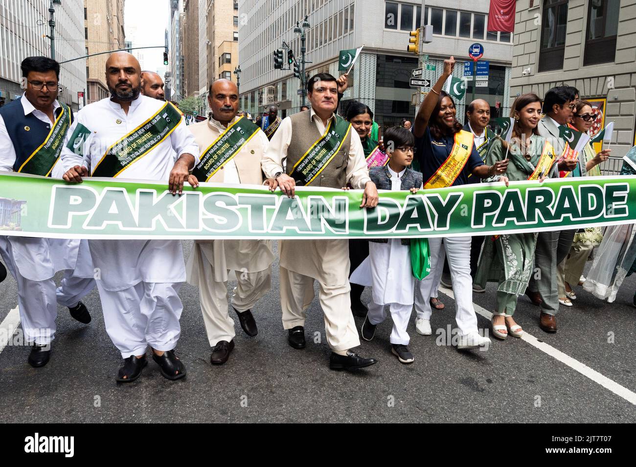 People marching with a banner saying "Pakistan Day Parade" at the New