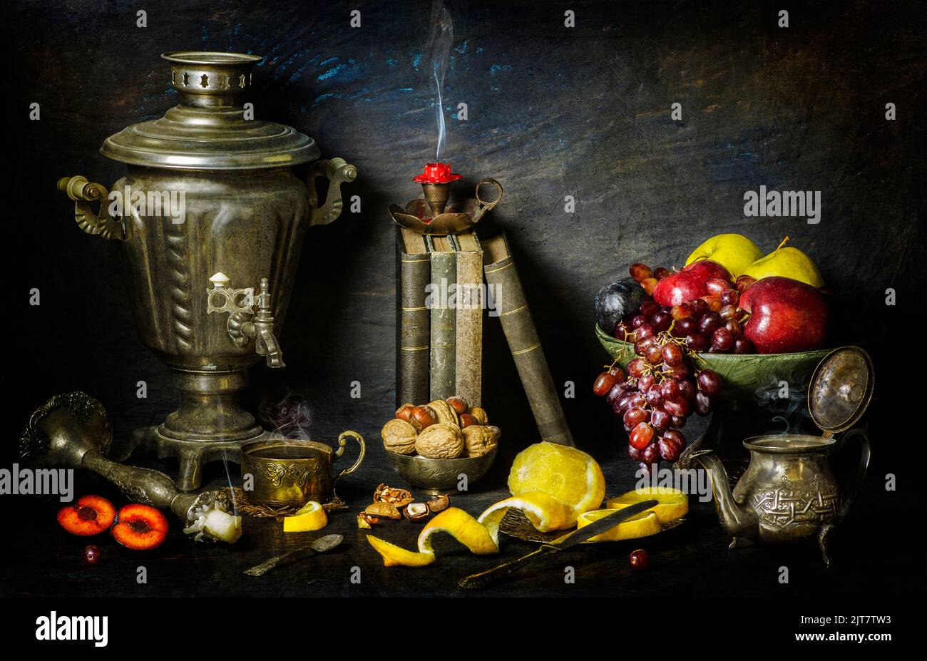 Classic still life with vintage books placed with old silver samovar, candlesticks, fresh fruits, cup of tea, tea pot and nuts on vintage background. Stock Photo