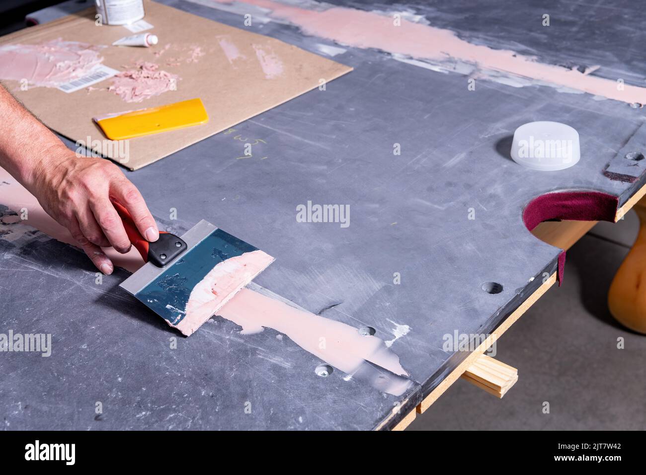 Pool table slate is sealed using a puddy knife Stock Photo