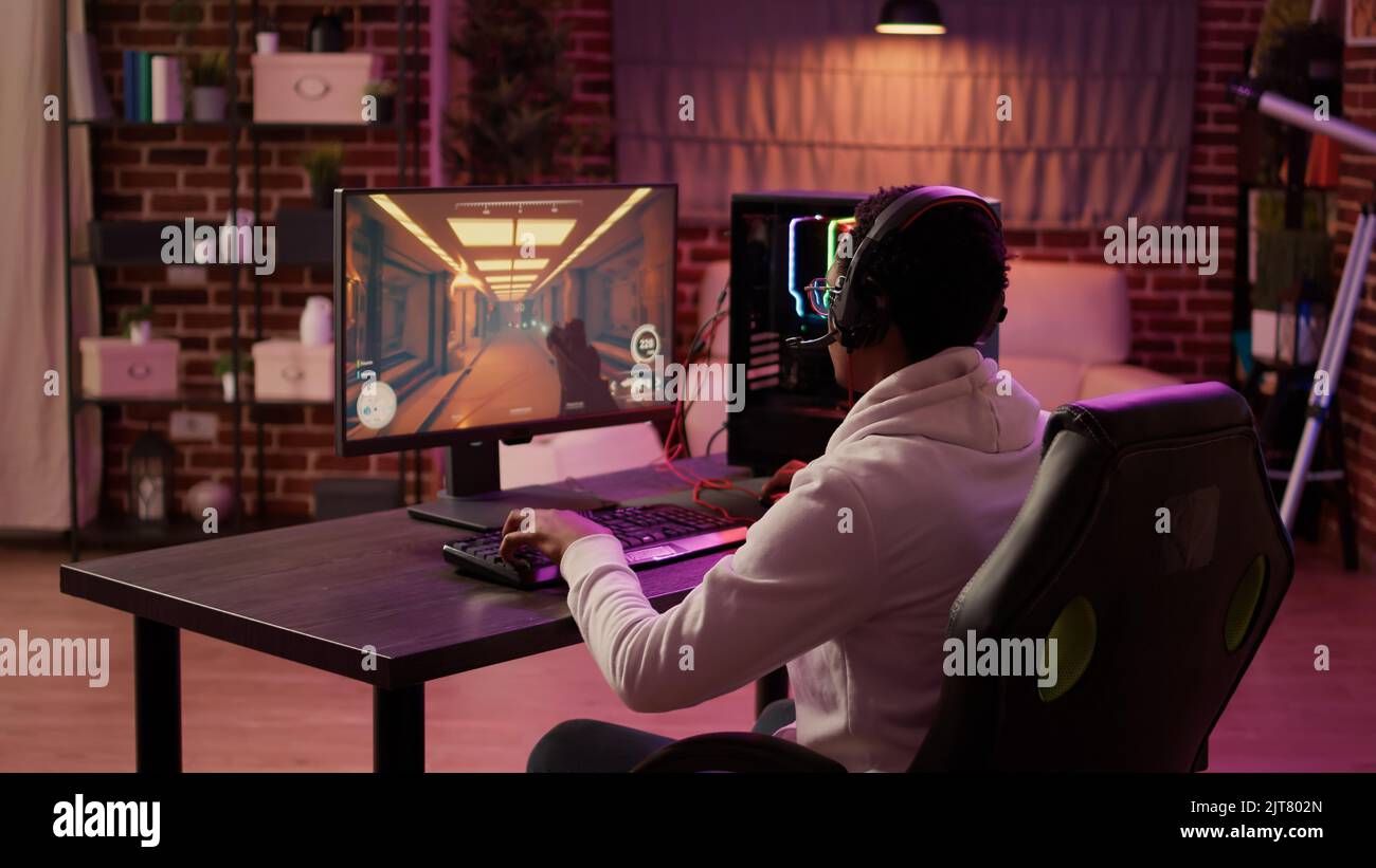 Over shoulder view of african american gamer using pc gaming setup ...