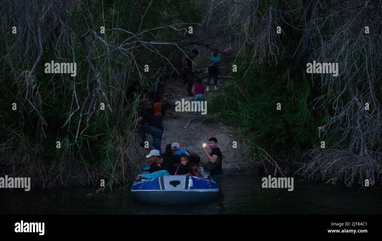 A man films with his smart phone while smuggling migrant families across the Rio Grande river into Roma, Texas, U.S., August 27, 2022.  REUTERS/Adrees Latif Stock Photo