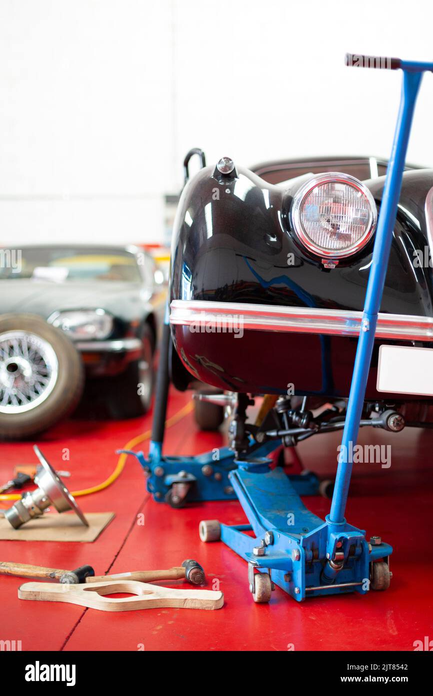 Close-up of several cars in workshop. Mechanics, repair, restoration, classic cars, transport. Space for text. Stock Photo