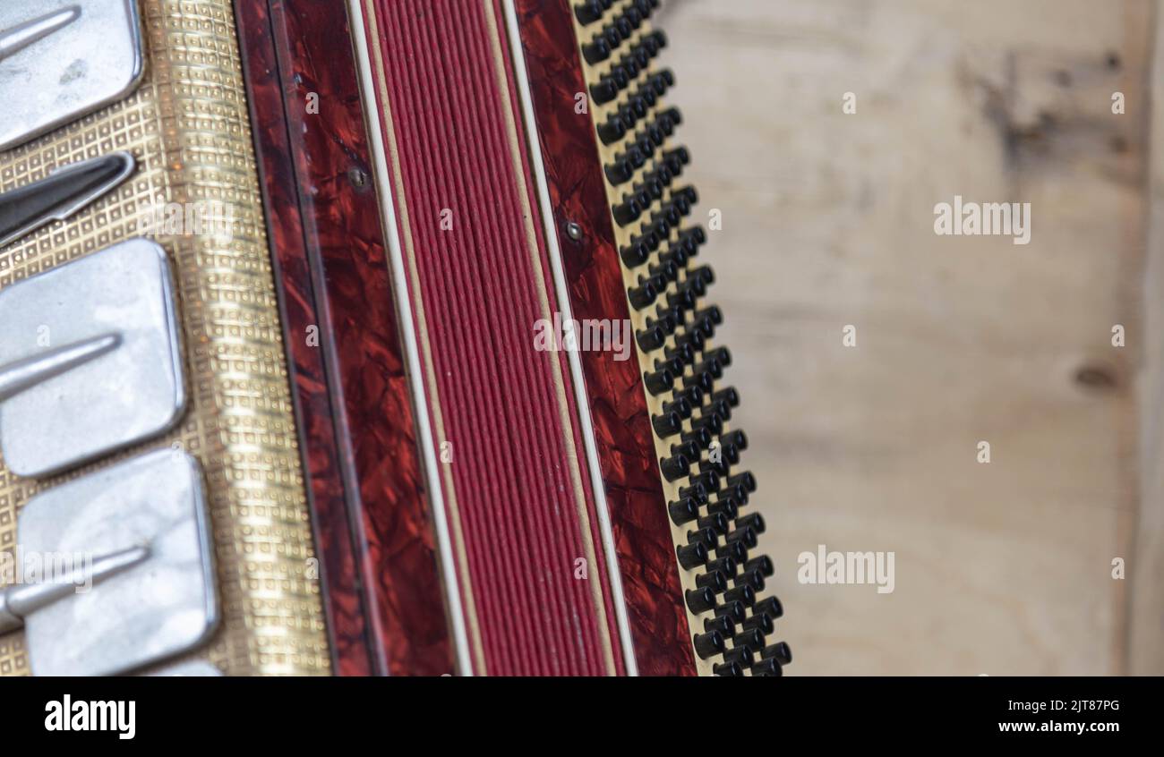 Old red accordion. Wind musical instrument. Old concertina. Musical