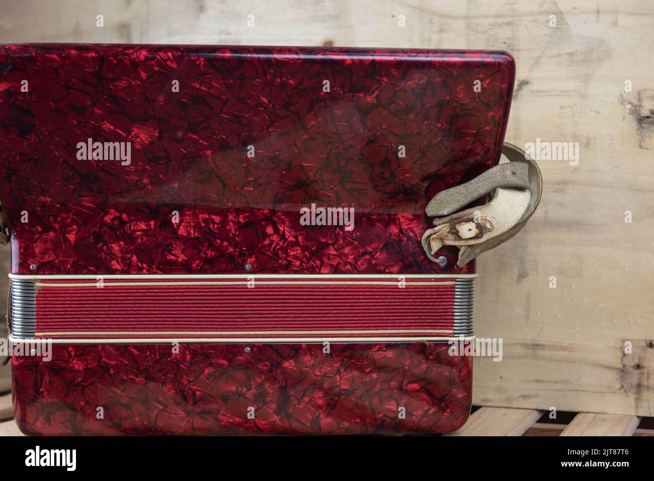 Old red accordion. Wind musical instrument. Old concertina. Musical